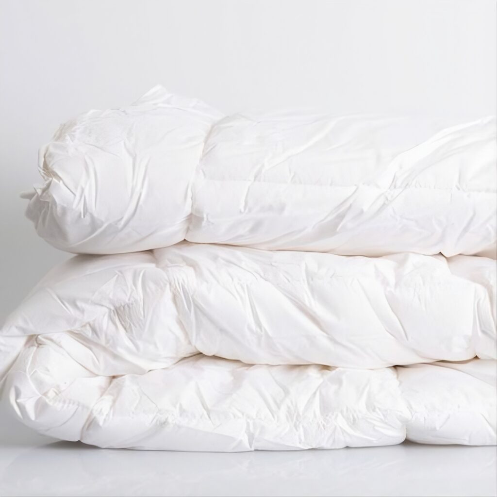 A neatly folded, clean white quilt with sharp, presentable edges, demonstrating the stable and bunch-free finish created by Kanga’s clip-in system.